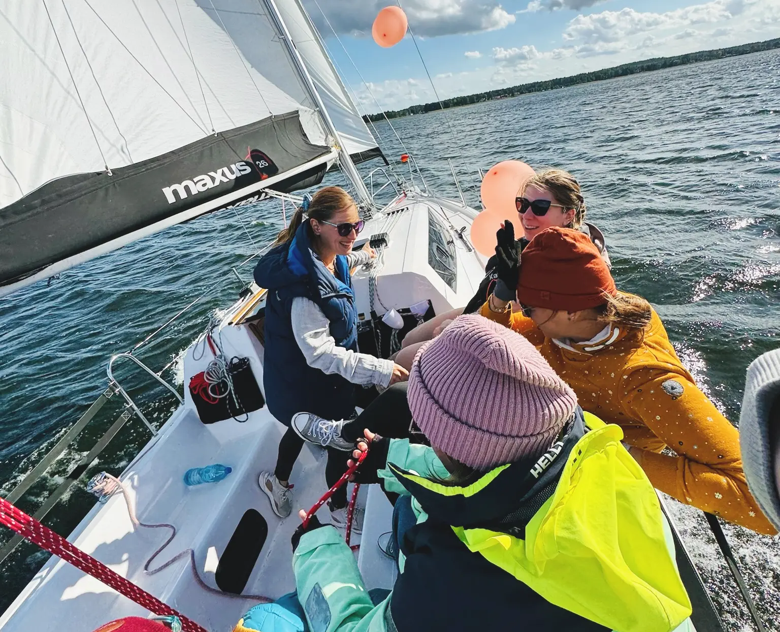 widok na jacht w przechyle od tyłu, załoga 4 osób się uśmiecha